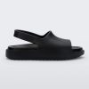 Side view of a matte black Mini Melissa Cloud sandal with a black insole, base and back velcro strap.