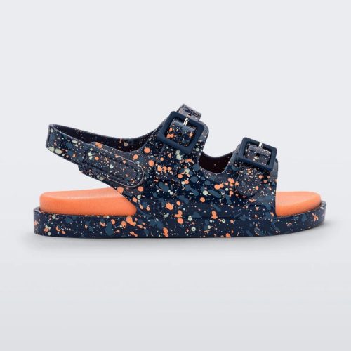 Side view of a blue/orange Mini Melissa Wide Sandal with a blue base with a splatter painted print, and an orange insole.