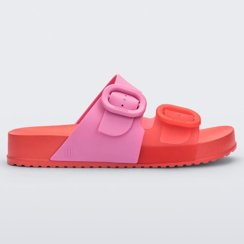 Side view of a Red/Pink Melissa Cozy slide with two red and pink straps with a buckle detail.