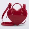 Front view of a red Heartbeat bag with small handles and longer strap.