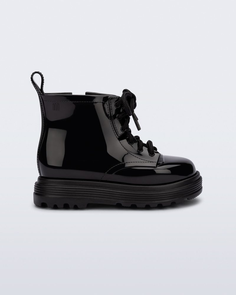 Side view of a black Coturno baby boot with black laces.