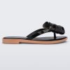 Side view of a Melissa slim strap flip flop in black with bow applique