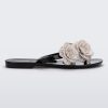 Side view of a black Harmonic Springtime women's flip flop with 3 beige flowers