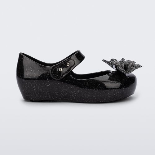 Side view of a black glitter Ultragirl Sweet baby ballerina flat with bow