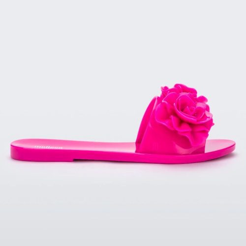 Side view of a neon pink Melissa Babe Garden slide with two flowers on the front strap.