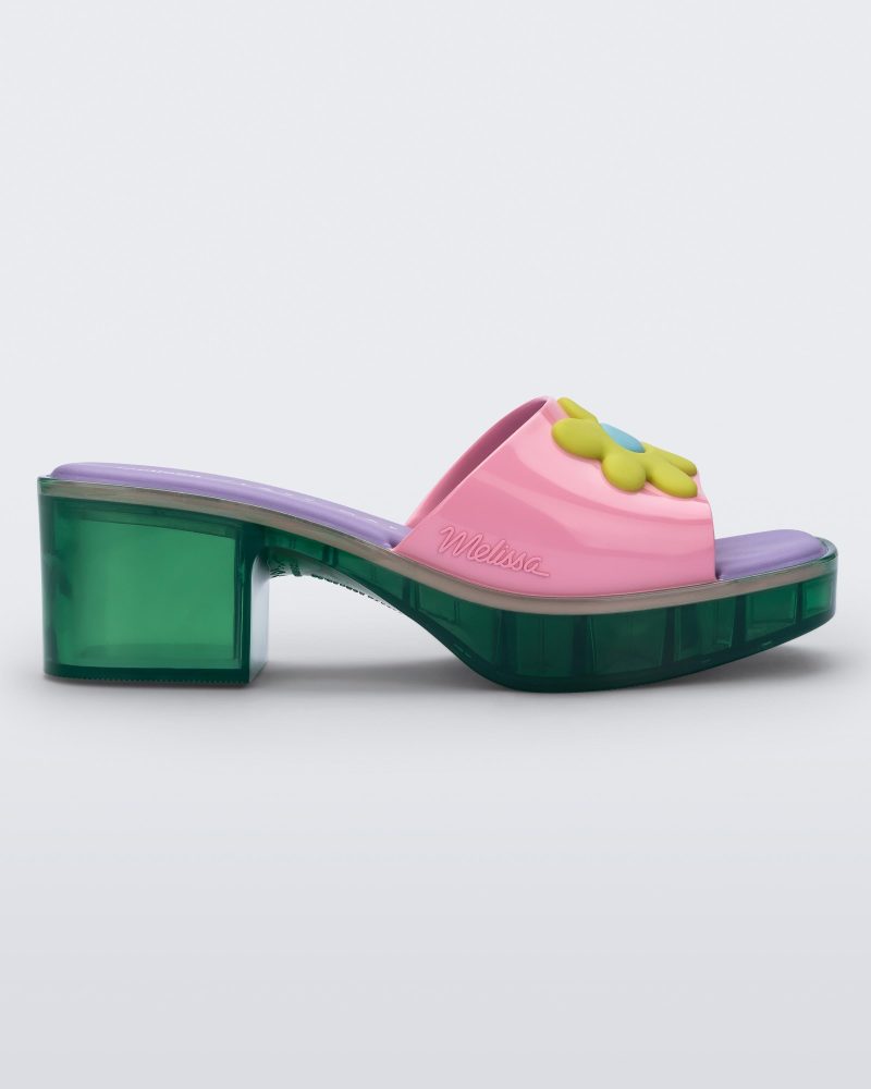 Side view of a Melissa Shape slide with green platform heel,  a pink wide front strap with a yellow and blue flower on the top of the strap and a purple insole