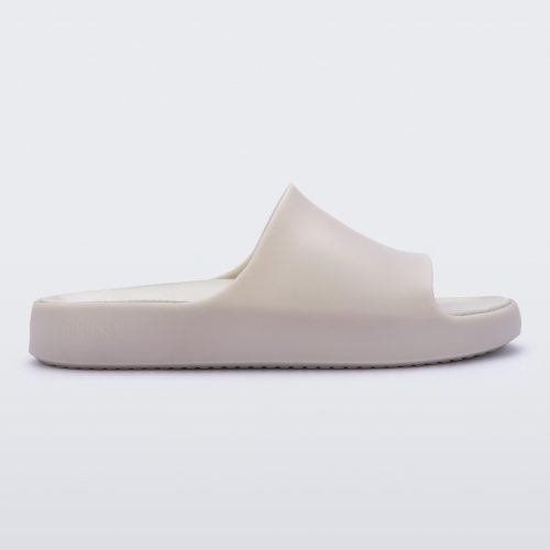 Side view of a matte beige Melissa Cloud slide.