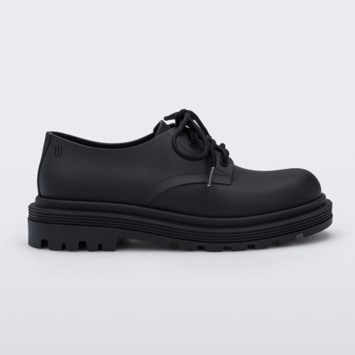 Side view of a matte black Melissa Bass sneaker, with a black base, laces and sole.