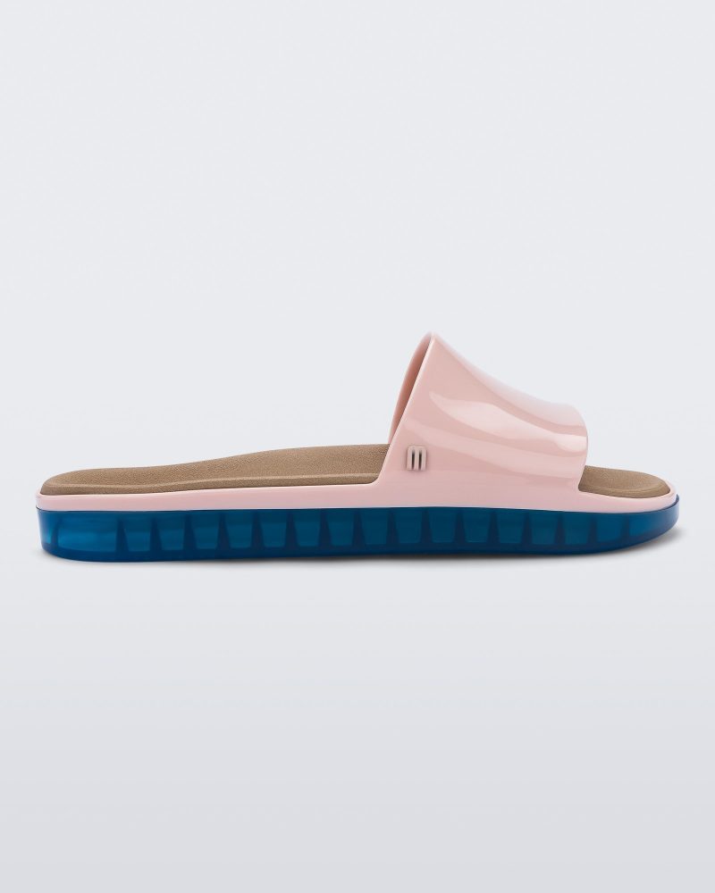 Side view of a pink Melissa Beach slide with blue sole.