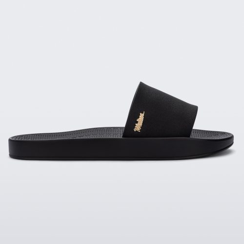 Side view of a Melissa Sun Sunset slide sandal in black with gold Melissa logo on the top side corner of the strap.