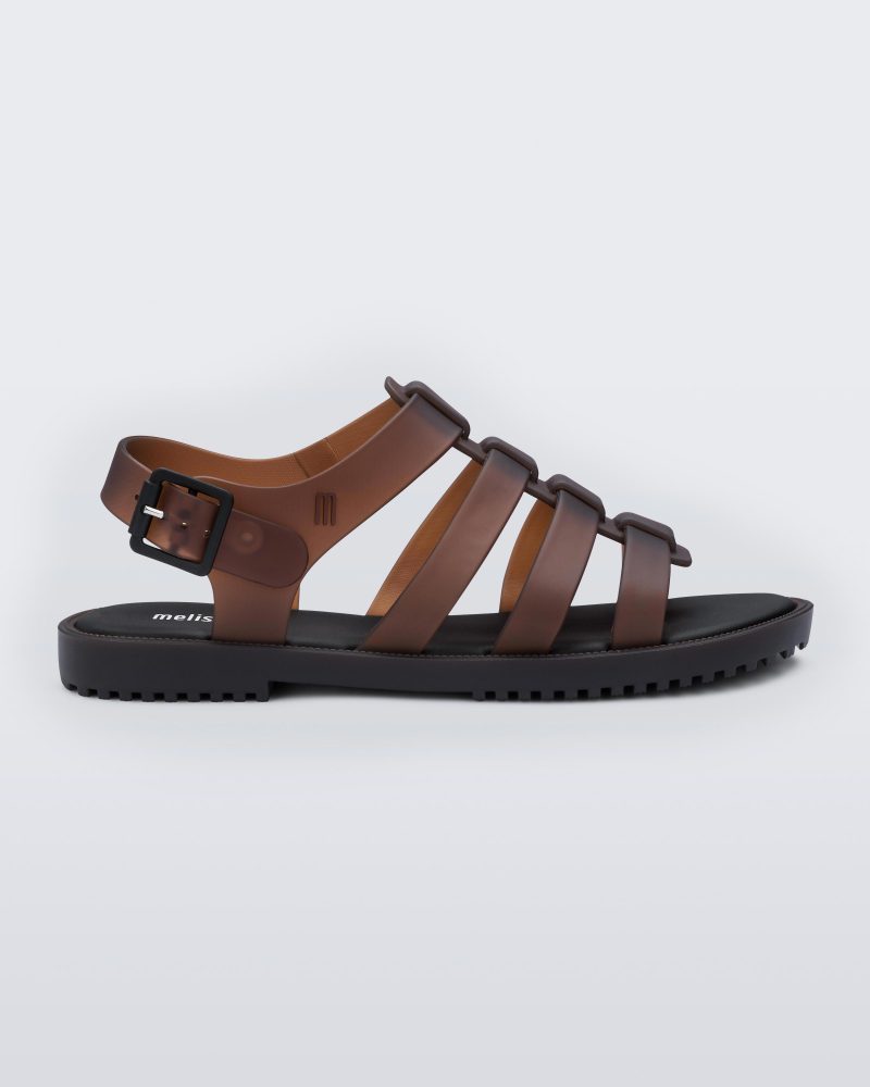 Side view of a clear brown Melissa Flox sandal with a black sole and straps.