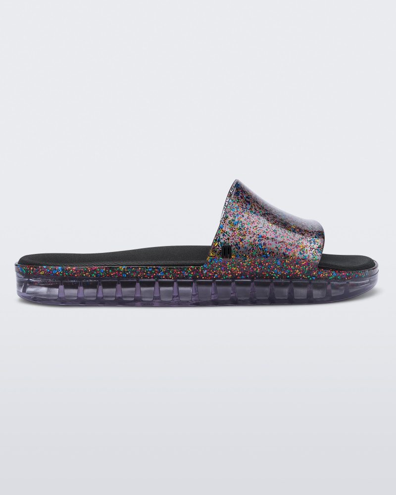 Side view of a clear/glitter Melissa Beach slide.