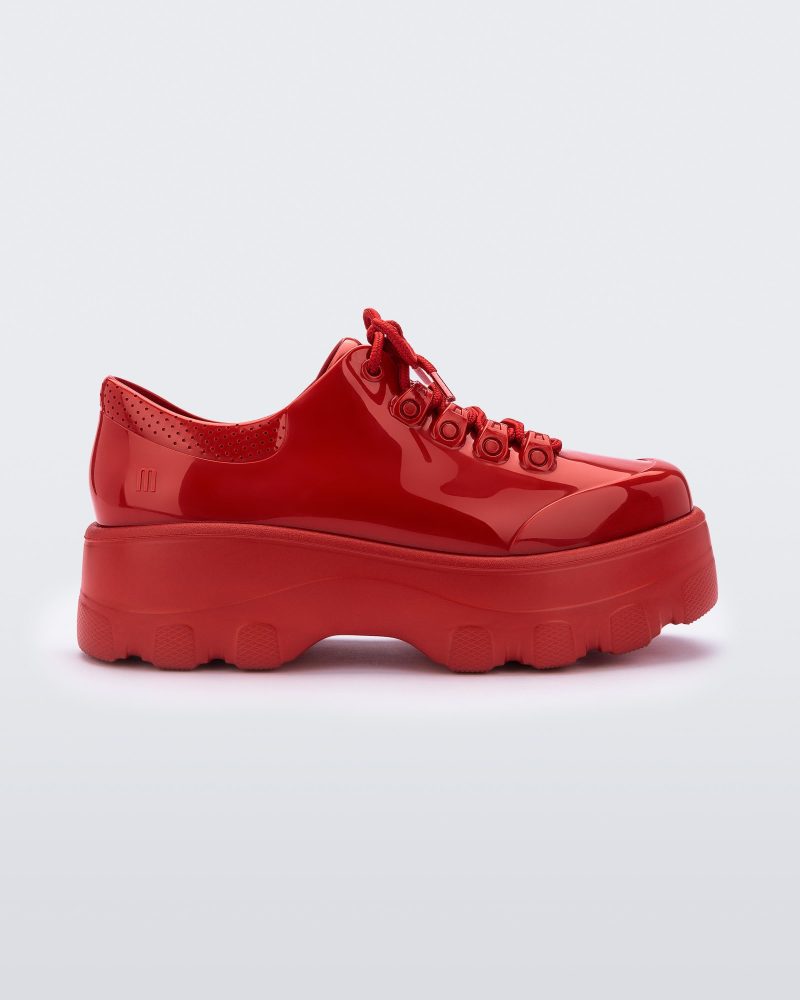 Side view of a Melissa Kick Off sneaker in red with platform sole and red shoe laces