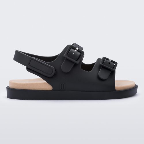 An outter side view of a black/beige Mini Melissa Wide Sandal with a black base, two black buckles at the top and a beige insole.